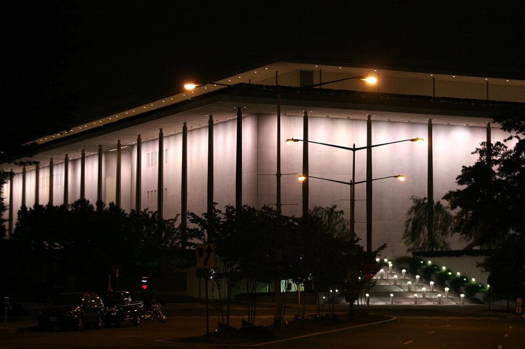 The Kennedy Center illuminated at night, a glowing stage for Trump’s rebranded cultural spectacle.